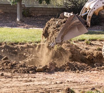 Small Bulldozer Digging In Yard For Pool Installation.